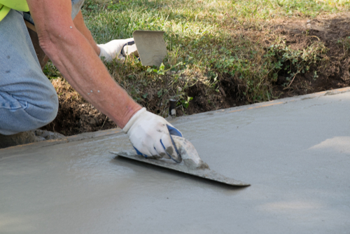 Using a hand tool to level out wet concrete